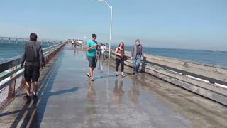 Guy Gets Wet Facing Big Waves Coming Over bridge