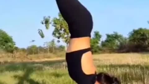 Pretty girl doing yoga on the farm