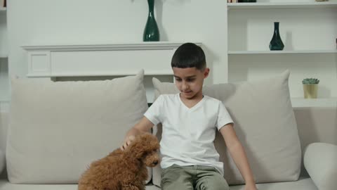 A Boy Petting His Dog While Sitting in a Couch
