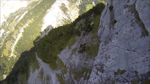Wingsuit flying along mountainside cliff