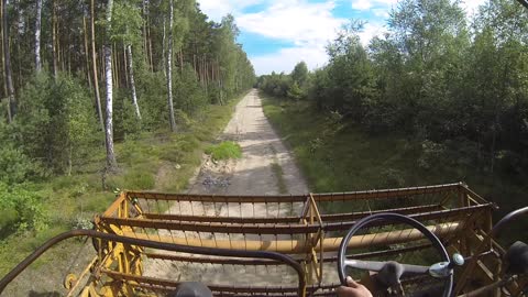 Farmer drives through the forest by harvester