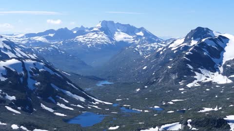 tilt up from a lake to a mountain landscape in jotunheimen national park norway