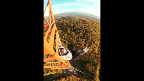CRAZY: Guy climbs dangerously high radio tower and does acrobatics at the top