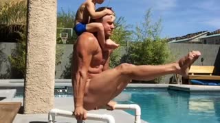 Boy enjoys snack during acrobat dad's workout