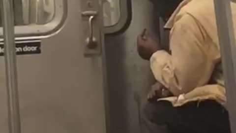 Man brown jacket smoking with subway doors open