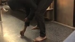 Barefoot woman counts change on subway floor