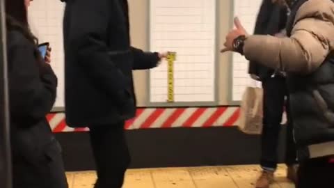 Two men dancing salsa on subway platform