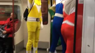 Four men dressed as power rangers on train