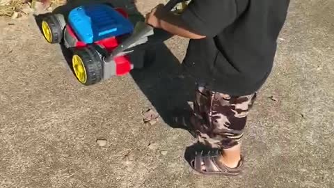 Toddler chasing his cat with the lawn mower
