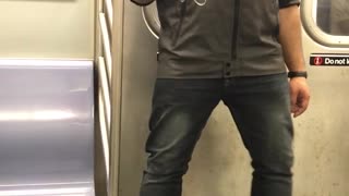 A man in blue shirt headphones dances on subway