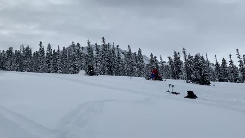 Guy Gets Thrown Off A Snowmobile When It Flips As He Drives Downhill