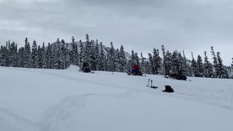 Guy Gets Thrown Off A Snowmobile When It Flips As He Drives Downhill