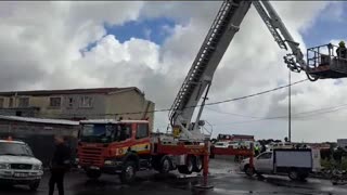 A fire truck crane moves over the damaged homes in Hanover Park.