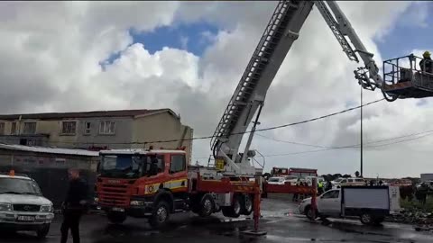 A fire truck crane moves over the damaged homes in Hanover Park.