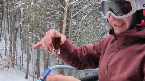 Skier Enjoys a Meal on Chairlift