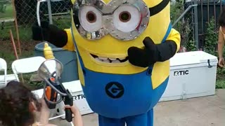 Houston mascot party character yellow helper minion plays banana vacuum game at birthday