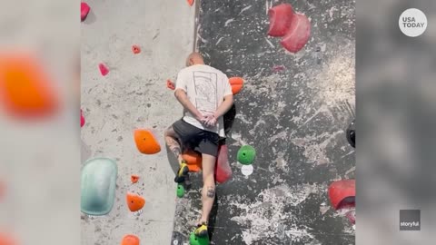 Rock climber impressively scales wall with hands behind his back