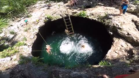 two-women-jumping-down-a-water-hole