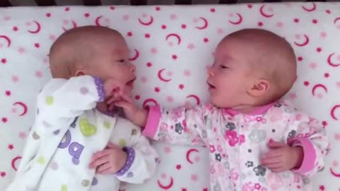 Identical twin girls engage in deep conversation