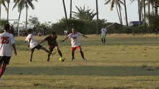 Show more Men Playing Football at Sunset A slow motion shot of people playing football