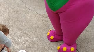 Houston mascot party character purple dinosaur Barney plays teacup stacking game at Teddy Bear park