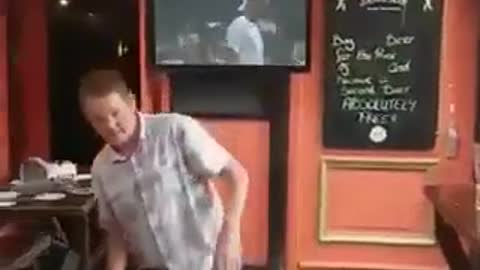 Drunk man at bar falls over onto table outdoor patio bar