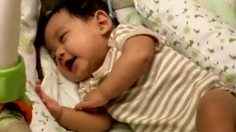 Cute baby laughing while sleeping