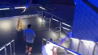 Three guys slide down stair rail