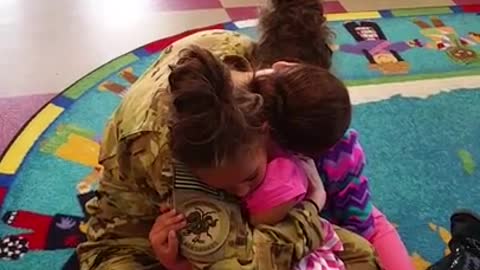Deployed mom surprises twin daughters at school