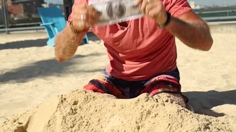 A Man Digging Money From the Sand.