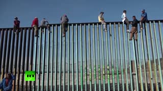 Caravan members jeering at DHS authorities from San Diego border fence
