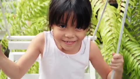 Little Girl Swings And Showing Funny Her Face