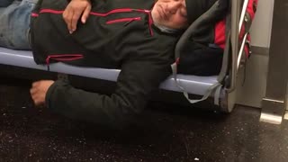 Man black jacket beanie asleep on train