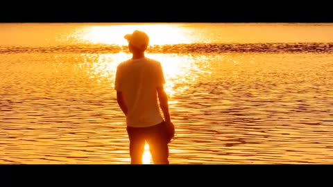 Teenager walking by the lake at sunset