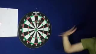 Guy shooting dart in between guys fingers
