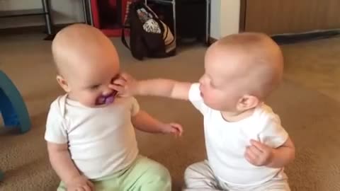 Twin baby girls fight over pacifier