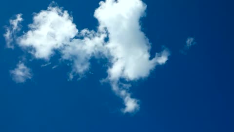 A white cloud passing through the blue sky