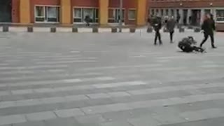 Man in black jacket runs falls and slides on brick road