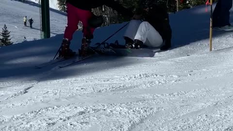 Guy white pants hanging on ski lift