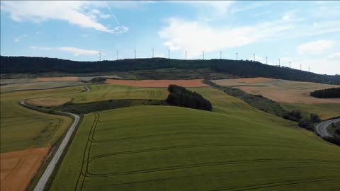 wind turbines for renewable energy and natural landscape with hills fields forests in spain