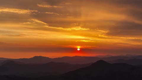 The sunset scenery makes the mountains in the distance draped in golden veil