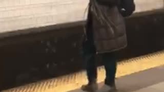 Girl in big jacket in subway holding a bunch of branches