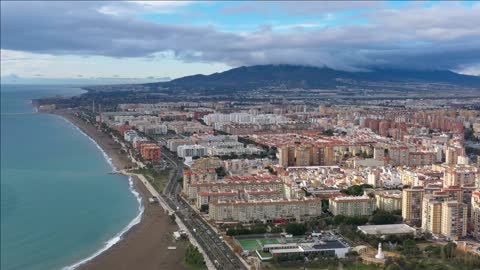 malaga beach of mercy dark sand west coast of the city spain aerial shot mountains in background