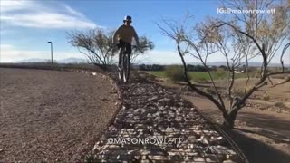 Guy beige brown shirt bike rocks front flip