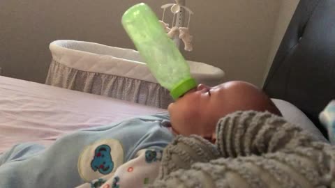 Baby needs no help whatsoever drinking his bottle