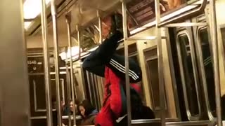 Man in spiderman outfit hangs from subway ceiling