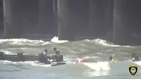 Kids get crushed by waves as they hold onto a pipe, firefighters & officers pull them to safety