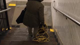 Woman pushes vacuum down public stairs