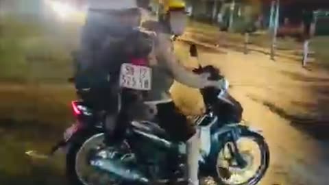 Surprised by the action of a motorbike carrying a young man on another motorbike