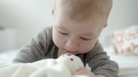 Cute baby playing with a teddy